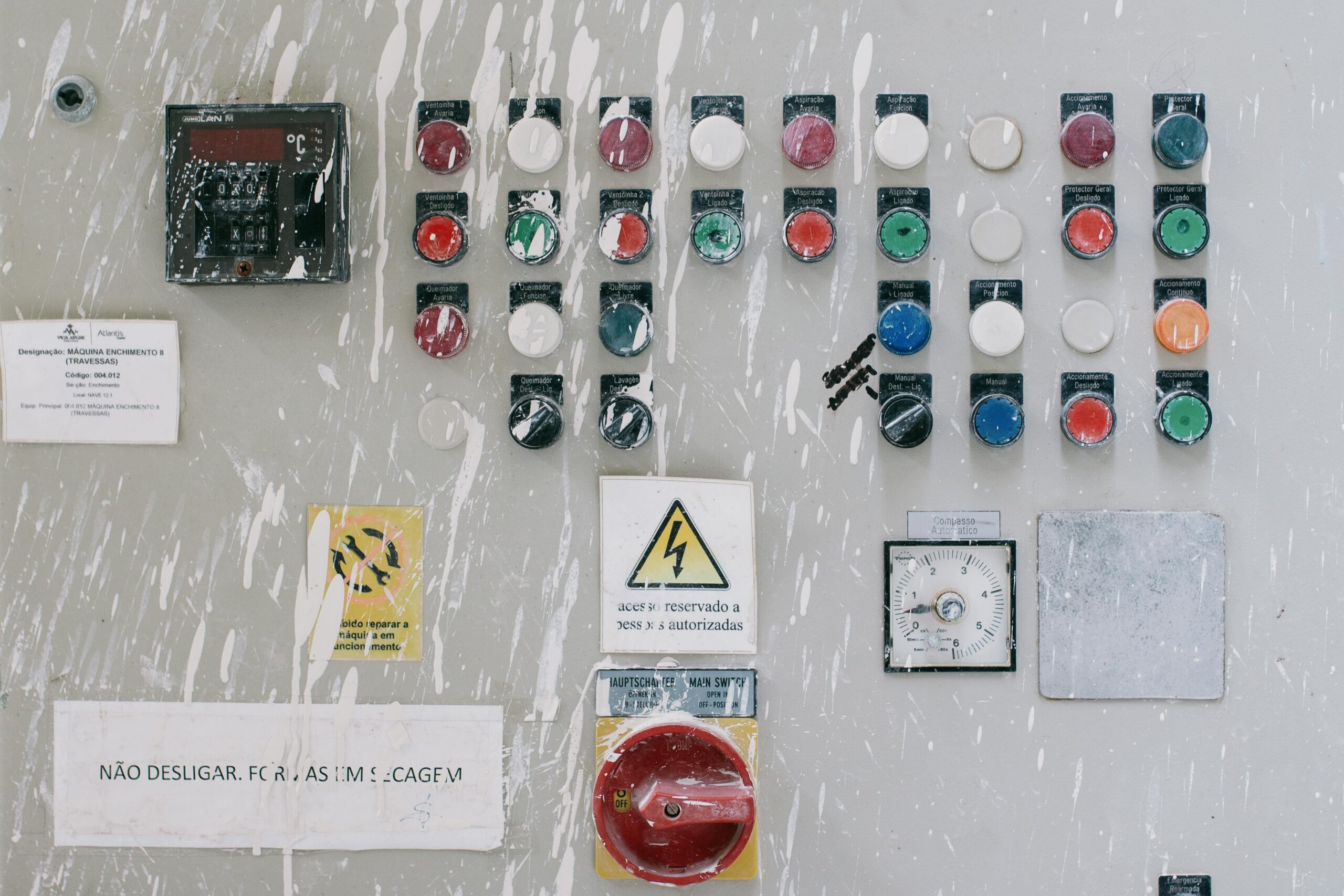 خدمات المعايرة والتحقق Close-up of an industrial control panel with colorful warning buttons and switches.